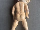 une petite poupée avec un chapeau sur la tête