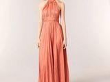 the woman in the dress is posing for the camera with her hands in her pockets