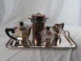un plateau en argent sur lequel sont posés une cafetière en argent et deux tasses