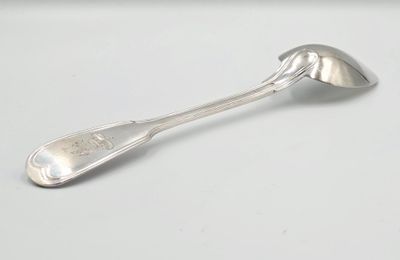 une cuillère en argent avec un manche de cuillère sur une surface blanche