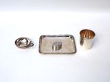 a silver tray and a silver cup on a white table