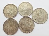 four different types of coins are shown on a white surface