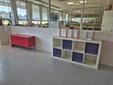 a room with a desk, shelves, and a red cabinet in it