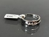 a silver ring with a tag on it on a table