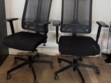 two black office chairs sitting next to each other on the floor