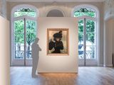 a painting on display in a large room with a statue in front of it