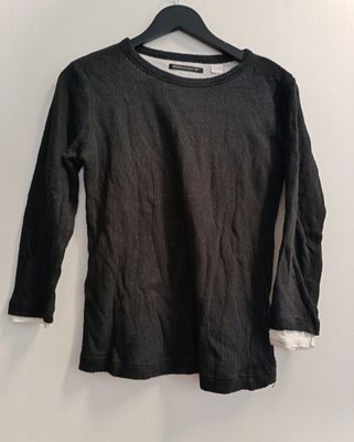 the shirt is black and white and has a long sleeve