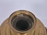a gold colored candle holder on a white surface