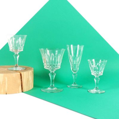 quatre verres à vin posés sur une table, à côté d'un morceau de bois