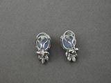 a pair of silver earrings on a gray surface