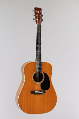 une guitare acoustique accrochée à un mur sur fond blanc