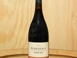 une bouteille de vin posée sur un tonneau en bois