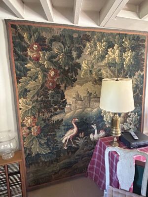 une grande tapisserie accrochée au mur derrière une table