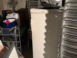 a stack of metal pans sitting on top of a refrigerator