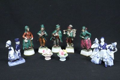 seven figurines of people dressed in different costumes