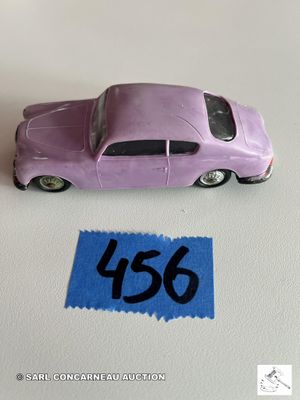 une petite voiture violette posée sur une feuille de papier bleue