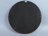 a black plate with a red edge on a white surface