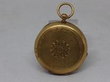 an image of a gold pocket watch sitting on a white surface