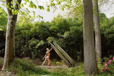 une femme debout dans l'herbe avec une planche de surf
