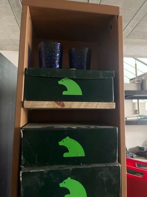 a shelf with three boxes and two cups on top of it