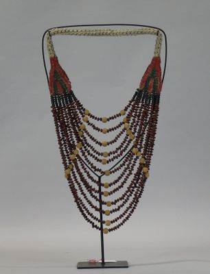 beaded necklace on a stand on a white background