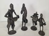 three bronze figurines of a man and a woman with baskets