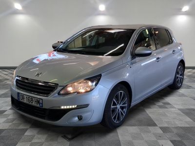 La voiture argentée est garée dans le showroom, sur le sol à damier.