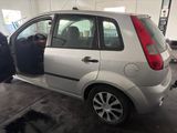 a small silver car with its door open in a garage
