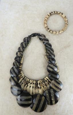 Deux colliers et un bracelet sont posés sur une table