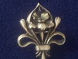 broche en forme de fleur de lys dorée sur fond bleu
