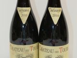 two bottles of wine sitting on top of a table next to each other
