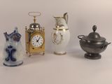 trois types de vases différents et une horloge posés sur une table