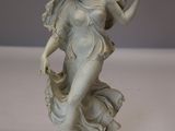 une statue de femme tenant un oiseau dans sa main