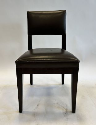 the back of a black leather chair against a white backdrop