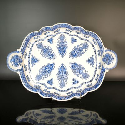 a blue and white plate on a black table