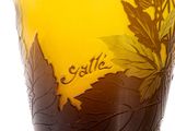 a yellow vase with leaves on it with a name written on it