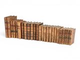 several old books are stacked on top of each other on a white surface