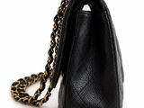 black leather handbag with gold chain strap on a white background