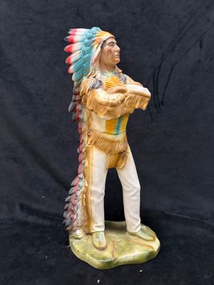 a figurine of a native american man holding a baseball bat