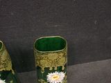 two green vases with white flowers on them