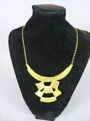un gros plan d'un collier en or autour du cou d'un mannequin