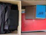 a box full of books and notebooks in it