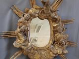 a mirror that has angels on it and a starburst in the middle