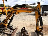 a yellow excavator that is sitting in the dirt