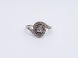 a close up of a diamond ring on a white surface