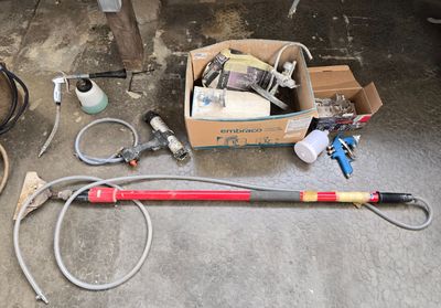 une boîte à outils posée par terre à côté d'un tuyau d'arrosage