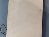 an old book on a blue table with a pen and pencil