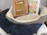 a dog bed with a bag of dog food and a bag of dog food on it