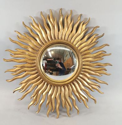 un soleil doré rayonnant, avec un miroir accroché au mur