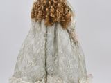 an image of a doll of a woman in a white dress and hat